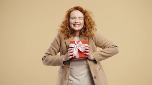 Happy woman holding gift with white bow