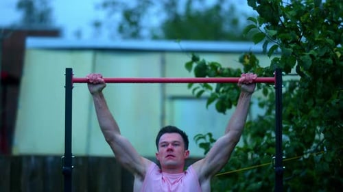 A Muscular Young Man Doing Pull-Ups Exercise On The Horizontal Bar Outdoors In Lithuania. - Medium S