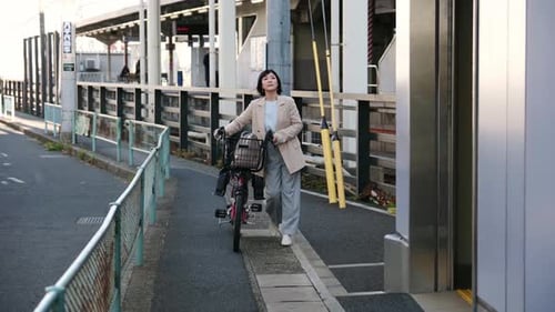 Woman Walking with Bicycle at Train Station Platform