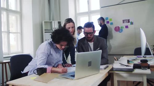 Young business team collaborating on a computer in a modern office space