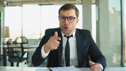 Furious Businessman Yelling Angrily at Camera in Office