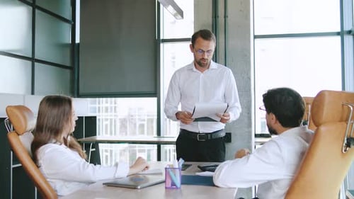 Business Meeting with Team Members Discussing Strategy in a Modern Office During Daytime