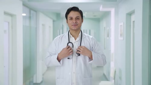 Smiling Doctor with Stethoscope in Hospital Corridor