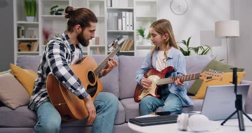 Man Teaching Child How to Play Guitar at Home
