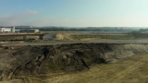 Visão ampla da construção de rodovias em andamento e da paisagem circundante.