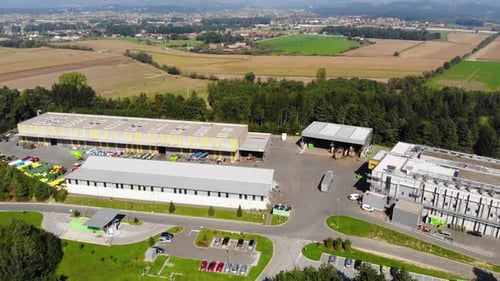 Plastic recycling plant with colored bins of different discarded containers, Aerial flyover view