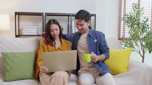 Couple Using Laptop Together on Couch at Home