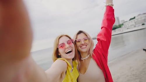 Two Beautiful Young Women Take a Selfie on a Tropical Beach The Girls are in a Good Mood Taking