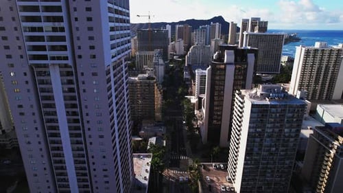 Cinematic shot flying slowly over city street in between buildings in Honolulu Hawaii.