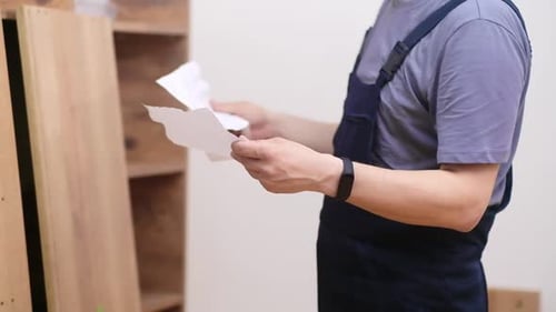 Adult Assembling Furniture With Instructions Indoors