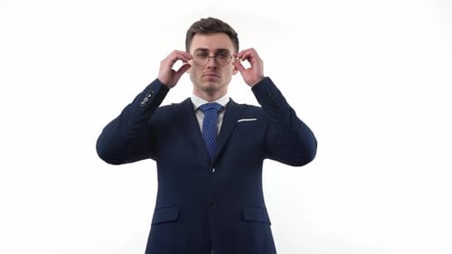 Handsome Male Businessman in a Suit Takes Off His Glasses and Shows a Gesture of Prohibition