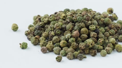 Dried green peppercorn seeds on white background
