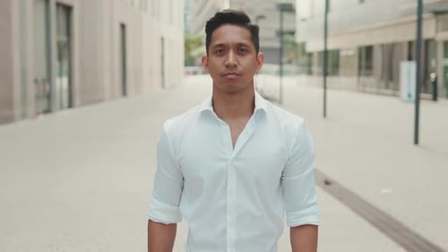 Young businessman looking at the camera while standing in the business district