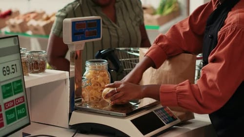 Merchant Using Scale at Cash Register Checkout in Organic Shop