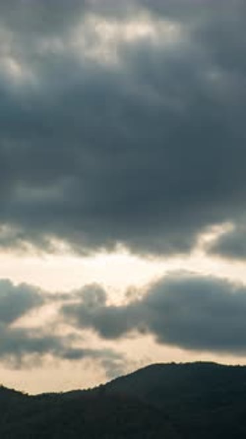 Dramatic Cloudscape Over Rolling Hills at Sunset