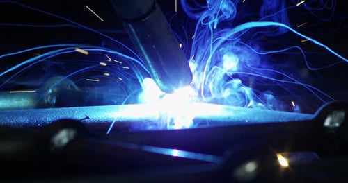.A blacksmith or welder, with his welder, welding steel and iron, in extreme slow motion. The weld