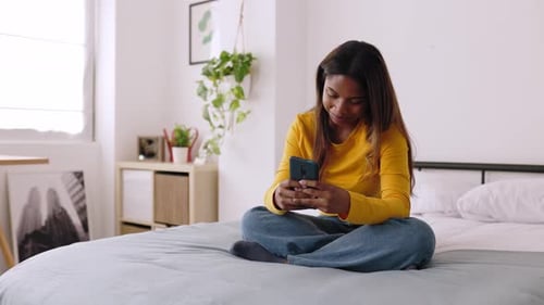 Young Adult Woman Using Phone on Bed