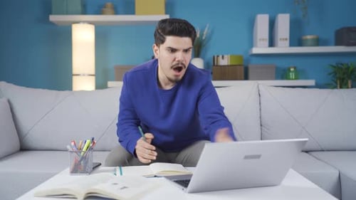 Frustrated Young Adult Working on Laptop at Home