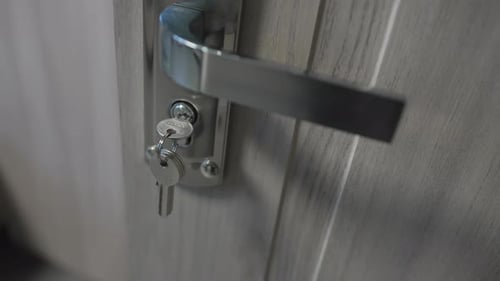 Chrome Handle Fitted with Key Adds Elegance to Wooden Door