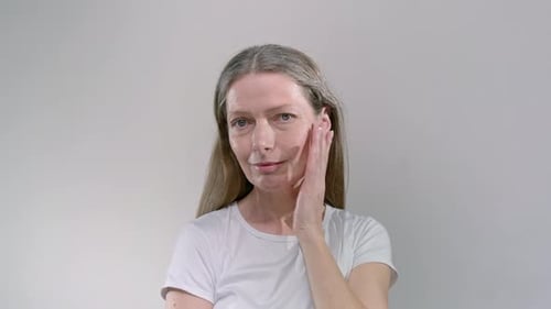 Woman Touches Her Face in a Skincare Routine