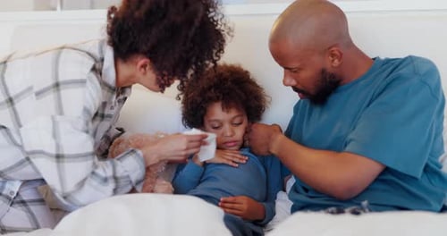 Parents Caring for Sick Child in Bed