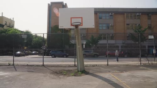Empty basketball court with sunlight falling on hoop, New York, USA