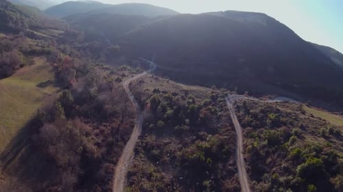 Areal shot of rally car on gravel mountain road