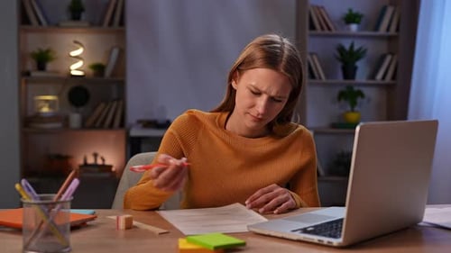 Femme écrivant des notes au bureau avec un ordinateur portable dans un environnement de bureau confortable