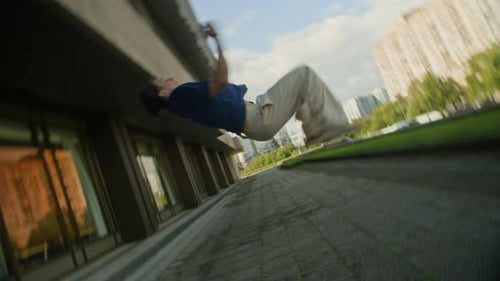 Skilled Young Man Performing Backflip in City Street