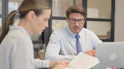 Colleagues Discussing Business at Office Desk