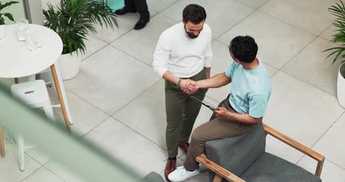 Two Men Discuss Technology in Modern Office