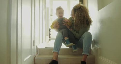 Woman Sits on Steps Holding Toddler