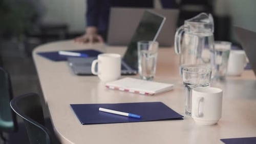 Prepared Conference Table with Water, Mugs, and Laptop
