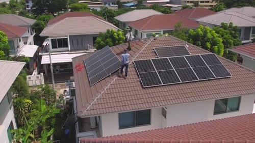 Drone view of engineer worker installed solar panels on roof of house.