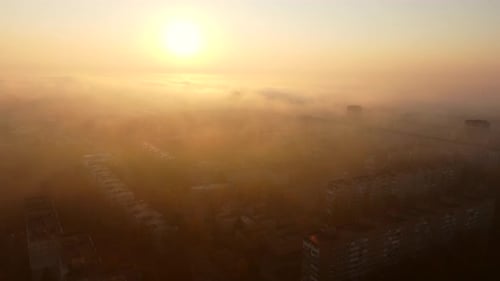Fog Blankets City Buildings During Sunrise