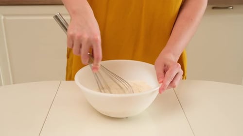Hands Mix Ingredients in a Bowl with a Whisk