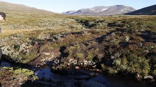 Solo male backpacker hiking in autumnal Scandinavian tundra landscape wearing a large backpack. Dovr