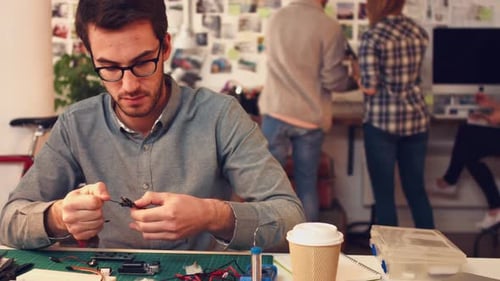 4k video of a young designer working with a circuit board in an office