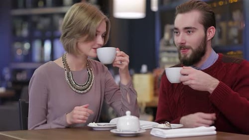 Charming Couple Savoring Coffee Together in a Cozy Cafe