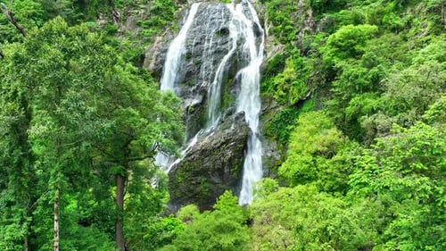 Beautiful waterfall in the green tropical forest. Drone aerial view.