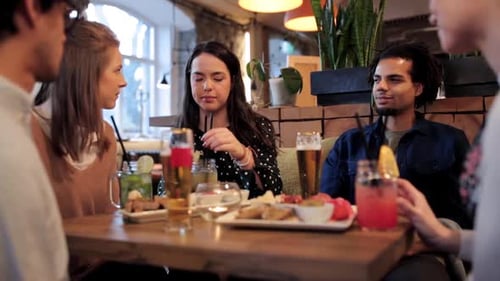 Friends Chatting Over Drinks at a Restaurant