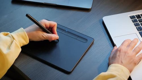 Fashion designer drawing on digital tablet.