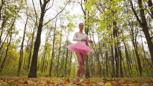 Alone in the Autumn Forest a Woman Performs Ballet Moves