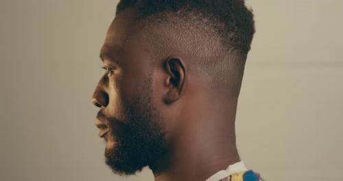 Close Up Portrait Of Bearded Young African American Man Turning His Head And Looking At The Camera
