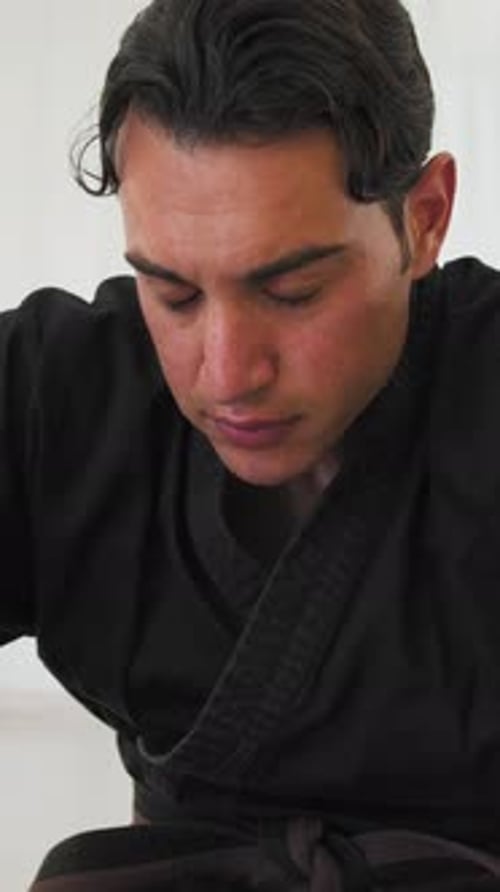 Man Does Stretching In Gym With Karate Uniform
