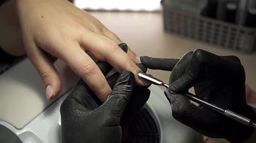Close up view. The master gives a manicure to a woman in a beauty salon.