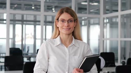 Confident Businesswoman Smiling Charmingly at Camera Working on Design in Office