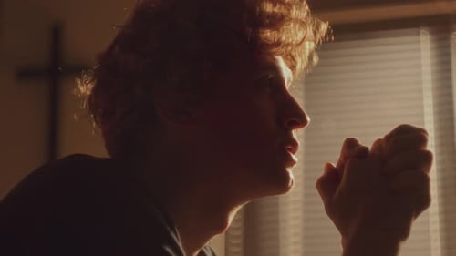 Young Adult in Prayer in Golden Light