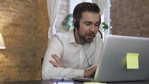 Businessman Using Laptop While Working in a Call Center