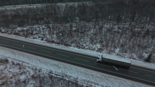 Single Truck Navigates Winter Terrain An Individual Truck Advances Along Snowcovered Winter Roadway